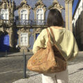 A woman with large cork bag in front of Raio Palace in Braga